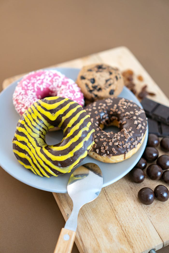 gallery-4 A tempting assortment of donuts with colorful toppings placed on a plate perfect for sweet cravings.