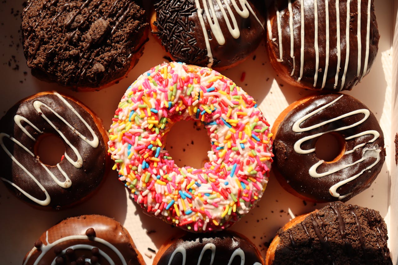 why-choose-us Bright and delicious donuts with sprinkles and chocolate, perfect for bakery promotions and dessert lovers.