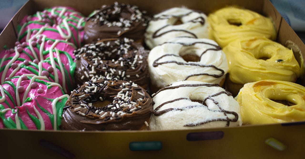 services-01 Colorful assortment of glazed and frosted donuts in a box, perfect for a sweet treat.